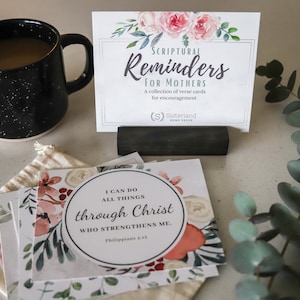 May include: A set of floral-themed encouragement cards with the text "SCRIPTURAL Reminders FOR MOTHERS A collection of verse cards for encouragement (S) Sisterland Home & Style" and "I CAN DO ALL THINGS through Christ WHO STRENGTHENS ME. Philippians 4:13".