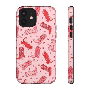 May include: Pink phone case with a pattern of red cowboy boots and stars.