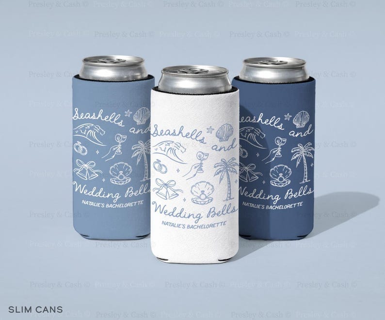 Three slim can coolers in soft blue, white, and navy with “Seashells and Wedding Bells” bachelorette design. Shown standing on a light blue surface with personalized bridal text.