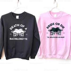 Peut inclure: Deux sweats &agrave; capuche noirs et roses avec un motif de cr&acirc;ne et d'os crois&eacute;s. Le sweat noir dit "Death of a Bachelorette" et le sweat rose dit "Bride or Die 'Til Death Do Us Part".