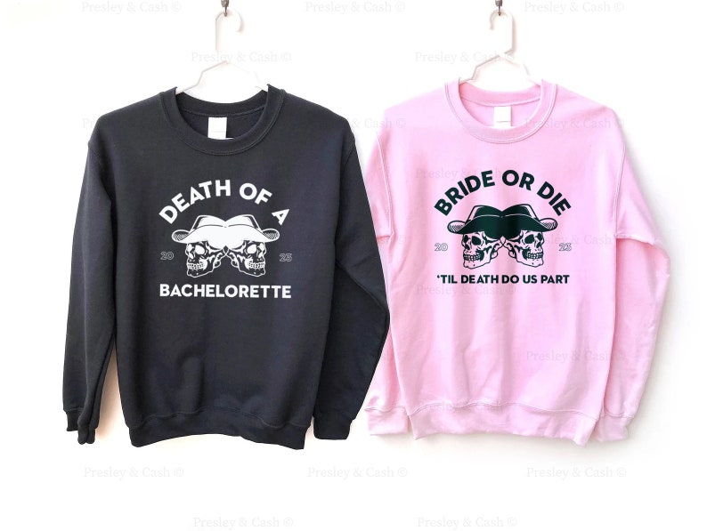 Peut inclure: Deux sweats &agrave; capuche noirs et roses avec un motif de cr&acirc;ne et d'os crois&eacute;s. Le sweat noir dit "Death of a Bachelorette" et le sweat rose dit "Bride or Die 'Til Death Do Us Part".