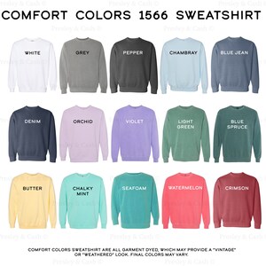 Op de afbeelding: Een tabel met 15 verschillende kleuren sweatshirts, elk met de kleurnaam erbij. De kleuren zijn wit, grijs, peper, Chambray, spijkerblauw, denim, orchidee, violet, lichtgroen, blauwspar, boter, krijtwit, zeeschuim, watermeloen en karmijnrood. De tekst "COMFORT COLORS 1566 SWEATSHIRT" staat bovenaan de tabel.