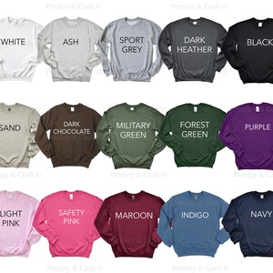 Peut inclure: Un assortiment de 12 sweat-shirts &agrave; col rond dans diff&eacute;rentes couleurs, notamment blanc, gris cendr&eacute;, gris sport, gris fonc&eacute;, noir, sable, chocolat fonc&eacute;, vert militaire, vert for&ecirc;t, violet, rose clair, rose s&eacute;curit&eacute;, bordeaux, indigo et marine. Chaque sweat-shirt a une couleur diff&eacute;rente et une &eacute;tiquette de texte avec le nom de la couleur.