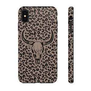 May include: A black and brown leopard print phone case with a black and white bull skull graphic in the center.