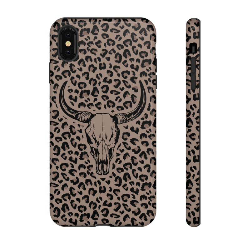 May include: A black and brown leopard print phone case with a black and white bull skull graphic in the center.