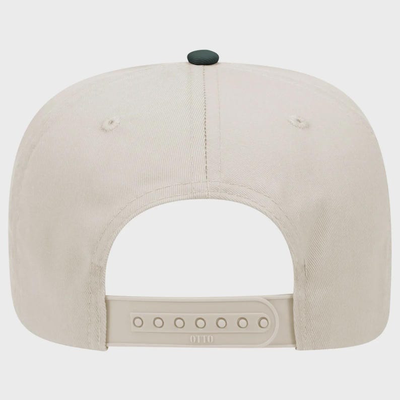 May include: A beige baseball cap with a dark green button on top. The back features an adjustable strap with the brand name "OTTO" printed on it. The cap is made of a soft, durable fabric.