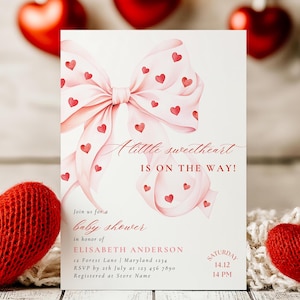 May include: A pink and white baby shower invitation with a watercolor bow and hearts. The text reads "A little sweetheart is on the way!" and includes details for the event, such as the date, time, and location.
