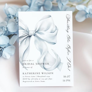 May include: A light blue bridal shower invitation with a watercolor illustration of a bow. The invitation text reads "Something Blue Before I Do!" and includes the bride's name, date, time, and RSVP information.