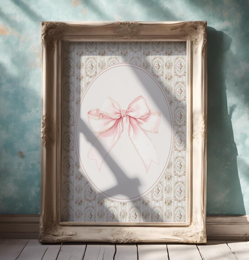 May include: A framed print of a pink bow on a white background with a floral pattern. The bow is tied with a ribbon and has a delicate, feminine look.