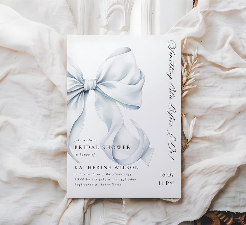 May include: A white bridal shower invitation with a blue watercolor bow and the text "Something Blue Before I Do!"  Join us for a Bridal Shower in honor of Katherine Wilson. 12 Forest Lane, Maryland 1234. RSVP by 12th July at 123 456 7890. Registered at Store Name. 16.07 14 PM.