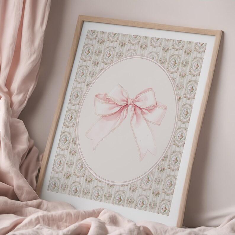 May include: A framed print with a pink bow on a light pink background with a floral pattern. The bow is tied with a large, soft loop and has a delicate, shimmery texture.