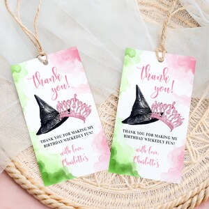 May include: Two pink and green thank you tags with a witch's hat and a princess crown. The text reads "Thank you!" and "Thank you for making my birthday wickedly fun! With love, Charlotte's".
