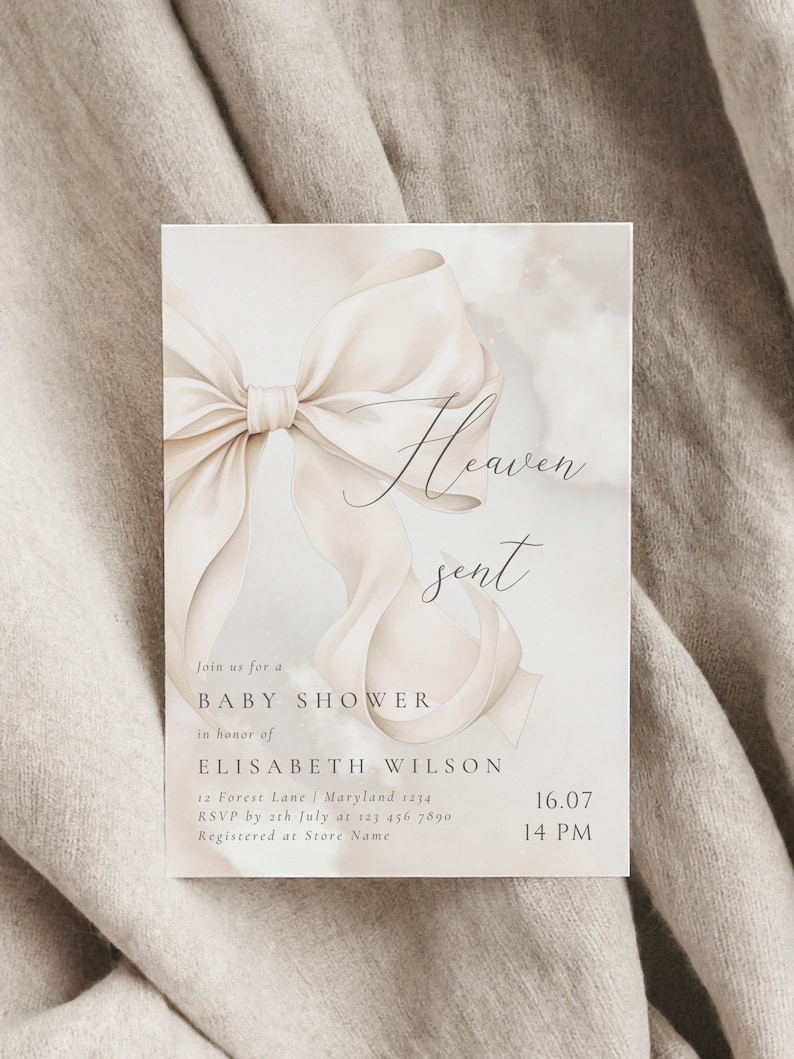 May include: A white and beige baby shower invitation with a large white bow and the text "Heaven sent" in cursive. The invitation includes the details of the event, including the date, time, and location.