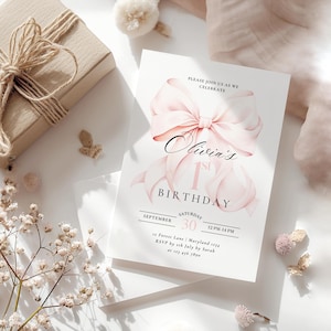 Pode incluir: Convite de anivers&aacute;rio rosa e branco com um grande la&ccedil;o rosa e o texto "Olivia's 1st Birthday". O convite inclui a data, a hora e o local da festa. As informa&ccedil;&otilde;es de RSVP tamb&eacute;m est&atilde;o inclu&iacute;das.