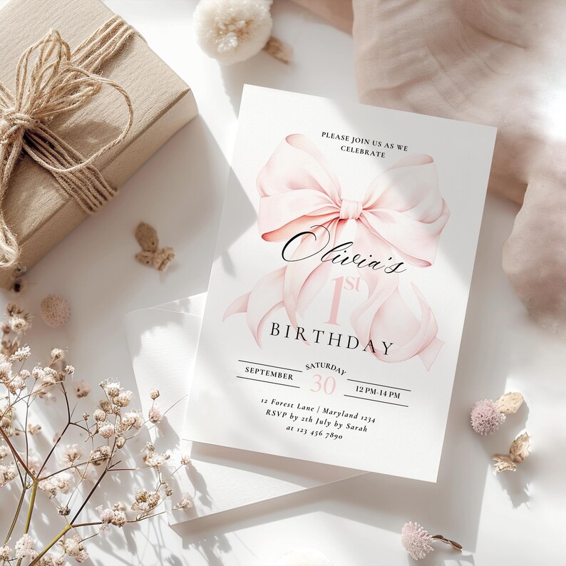 Pode incluir: Convite de anivers&aacute;rio rosa e branco com um grande la&ccedil;o rosa e o texto "Olivia's 1st Birthday". O convite inclui a data, a hora e o local da festa. As informa&ccedil;&otilde;es de RSVP tamb&eacute;m est&atilde;o inclu&iacute;das.