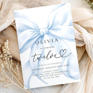 May include: A light blue birthday invitation featuring a watercolor bow design. The invitation reads "OLIVIA is turning twelve" in elegant script. Additional text includes the date, time, and location of the party.
