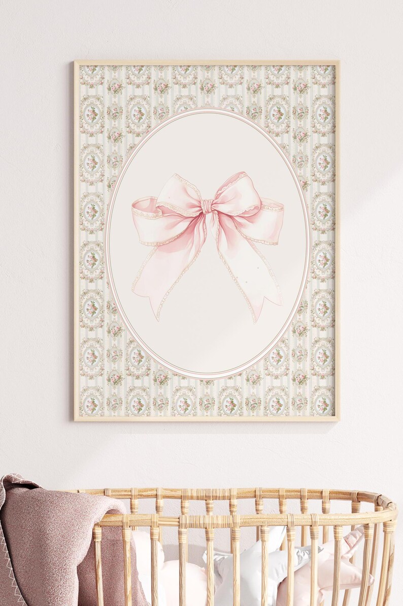 May include: A framed print with a pink bow on a white background. The frame has a light wood finish and the background is a light green and white floral pattern.