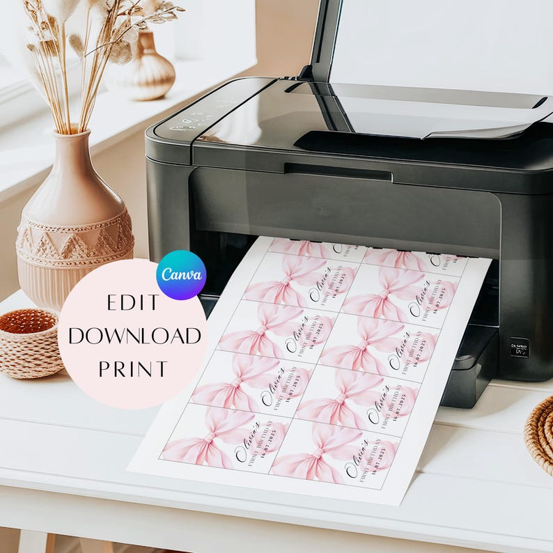 May include: A black printer printing sheets of pink bow-themed labels. Each label features a watercolor bow design and text. The image also shows a vase with dried flowers and a decorative basket.