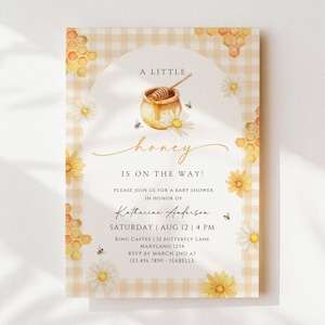 Puede incluir: Invitación a un baby shower con temática de miel. El diseño presenta una ilustración de acuarela de un tarro de miel, abejas y margaritas. El texto dice "A Little Honey Is On The Way!" e incluye los detalles del evento.