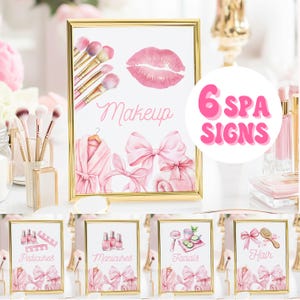 May include: A set of six spa signs in gold frames. The signs feature pink watercolor illustrations of makeup brushes, lips, a robe, bows, and spa treatments. The text "Makeup", "Pedicures", "Manicures", "Facials", and "Hair" are displayed.
