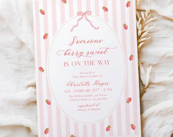 May include: Pink and white striped baby shower invitation with strawberry accents. The invitation features the text "Someone berry sweet IS ON THE WAY" in elegant script, along with event details.