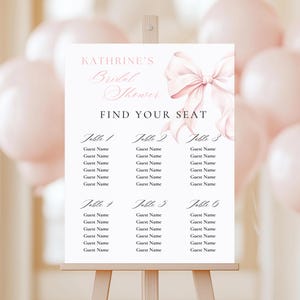 May include: A printable bridal shower seating chart with a pink bow and the text "KATHRINE'S Bridal Shower Find Your Seat" at the top. The chart is divided into six tables, each with space for six guest names.