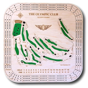 May include: A wooden cribbage board game featuring a map of The Olympic Club Ocean Course in San Francisco, California. The board has a green and brown color scheme and includes the course's par and hole numbers.