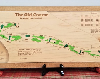 May include: A wooden map of the Old Course at St. Andrews, Scotland, with green painted holes and a quote by Lee Trevino. The map includes a scorecard with par and yardage for each hole.