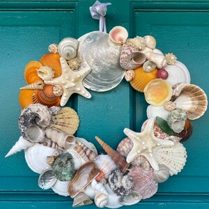 Beautiful 12” coastal seashell wreath wall hanger. Stunning combination of colors and textures with star fish and iridescent sea shells