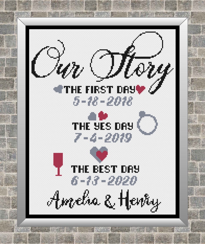 May include: A white cross-stitch design with black text that reads "Our Story" and includes three dates with descriptions: "The First Day", "The Yes Day", and "The Best Day". The dates are 5-18-2018, 7-4-2019, and 6-13-2020. The design also includes a heart, a ring, and a wine glass. The names Amelia and Henry are written at the bottom.