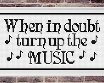 Pode incluir: Design de ponto cruz em preto e branco com o texto "When in doubt turn up the MUSIC" e notas musicais.
