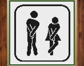May include: Black and white restroom sign with a stick figure of a person with their hands on their hips. The sign is framed in a gold frame with a green mat.