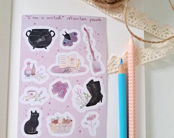 May include: A sticker sheet with a witch theme, featuring a black cauldron, a butterfly, a broom, a black cat, and other witchy items. The text "I'm a witch starter pack" is at the top. Two colored pencils and a ball of twine are also visible.