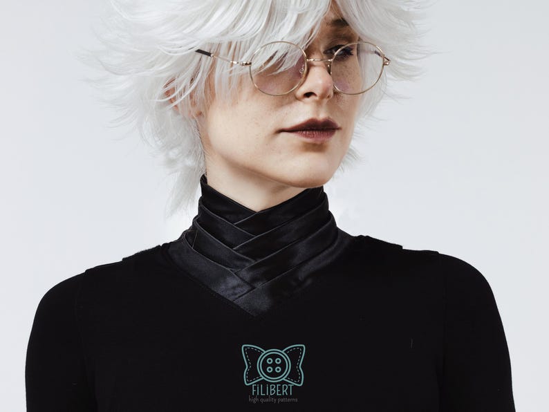 May include: A black long-sleeved shirt featuring a high, crisscross-layered collar design. The garment includes a light blue logo on the chest depicting a stylized bow tie with a four-hole button in the center and the text FILIBERT high quality patterns.