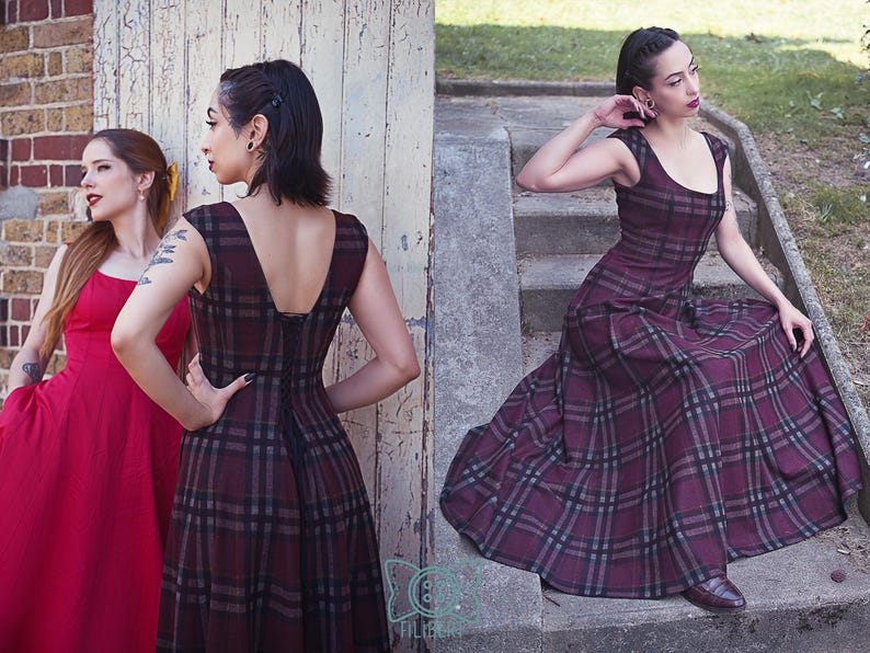 May include: Two women in dresses. One in a red dress, the other in a burgundy plaid dress with a scoop neckline and a flared skirt. The plaid dress has a black and gray pattern. The woman in the plaid dress is sitting on concrete steps.
