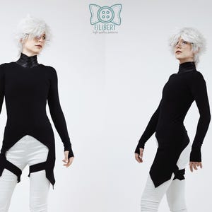 May include: A black long-sleeved top with a high collar, thumb holes, and an asymmetrical hemline that extends down the sides. The garment features a logo at the top center with the text FILIBERT high quality patterns. White pants are worn.