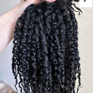 Peut inclure: Un paquet d'extensions de cheveux noirs pr&eacute;sentant des boucles en spirale serr&eacute;es et d&eacute;finies. Les cheveux ont une texture sombre et brillante avec des motifs en spirale uniformes sur toute la longueur. Le chiffre 7 est affich&eacute; dans un encadr&eacute; blanc.