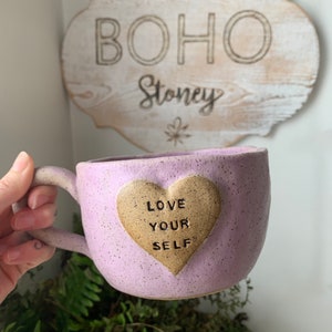 May include: Purple ceramic mug with a heart-shaped design that says "Love Your Self".