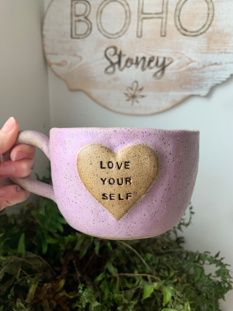 May include: Purple ceramic mug with a gold heart that says "Love Your Self" on it.