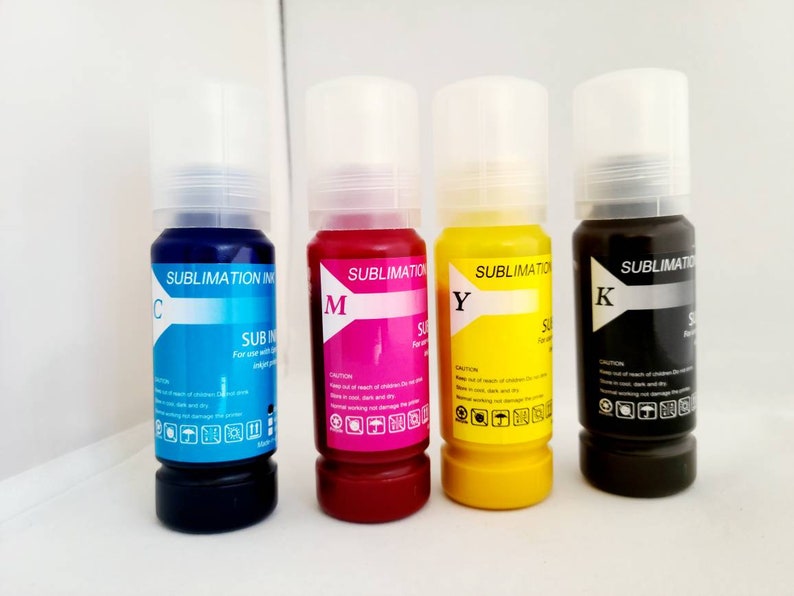 May include: Four bottles of sublimation ink, labeled C, M, Y, and K. The bottles are clear with black caps and contain blue, magenta, yellow, and black ink.