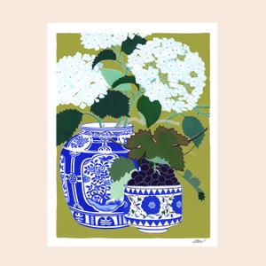 May include: A still life print featuring a blue and white patterned vase filled with white hydrangeas. A smaller matching bowl holds dark grapes. The background is a muted olive green.