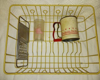 Wyposażenie kuchni: zabytkowy sito do mąki, tarka, szklanka do picia, druciany ociekacz do naczyń.