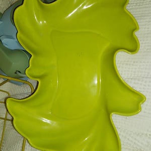 Peut inclure: Un plat de service vert-jaune vif en forme de feuille. Le plat a une finition brillante et un design organique unique. Il est probablement fait de céramique ou d'un matériau similaire. Le plat est vide et prêt à être rempli de nourriture.