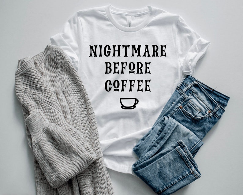 K&ouml;nnte beinhalten: Wei&szlig;es T-Shirt mit schwarzem Text, der "Nightmare Before Coffee" lautet, und einem kleinen Kaffeetassen-Symbol.