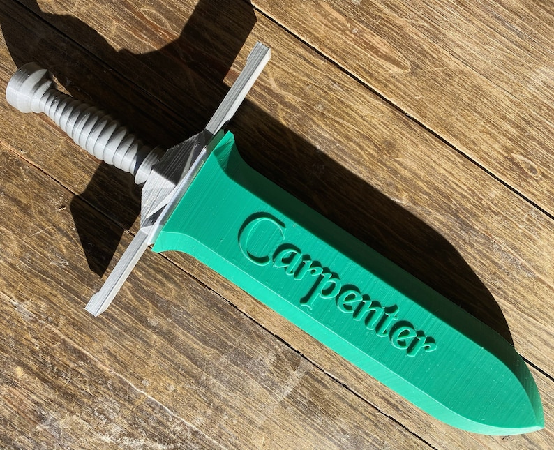 May include: A green plastic sword with a silver handle. The word "Carpenter" is printed on the blade.
