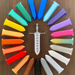 May include: A silver sword with a black handle surrounded by 20 colorful plastic sword replicas arranged in a circle. The replicas are in shades of blue, green, yellow, orange, red, brown, and gray.
