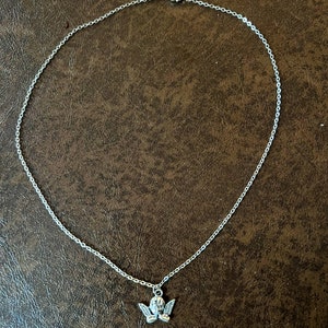 以下が含まれることがあります： 小さな天使のペンダントが付いたシルバーチェーンネックレス