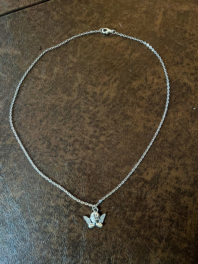 以下が含まれることがあります： 小さな天使のペンダントが付いたシルバーチェーンネックレス