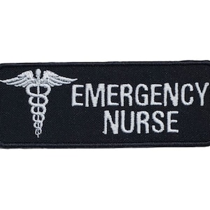 May include: Black embroidered patch with a white medical symbol and the text "EMERGENCY NURSE".
