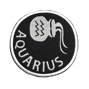 May include: A black and white embroidered patch with the word "Aquarius" in a circle around a stylized image of a water pitcher.